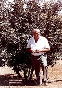 Oskar Schindler standing in front of the tree planted in his honor at Yad Vashem  1970